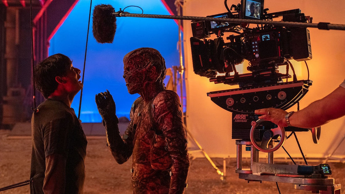 Plan zdjęciowy Stranger Things: kamera, mikrofon na tyczce i niebieskie tło przed aktorem w charakteryzacji stwora