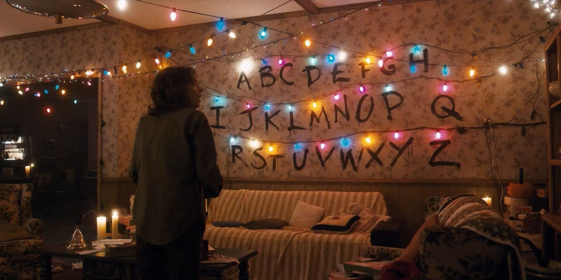 Joyce przed ścianą alfabetu z zapalonymi lampkami w Stranger Things